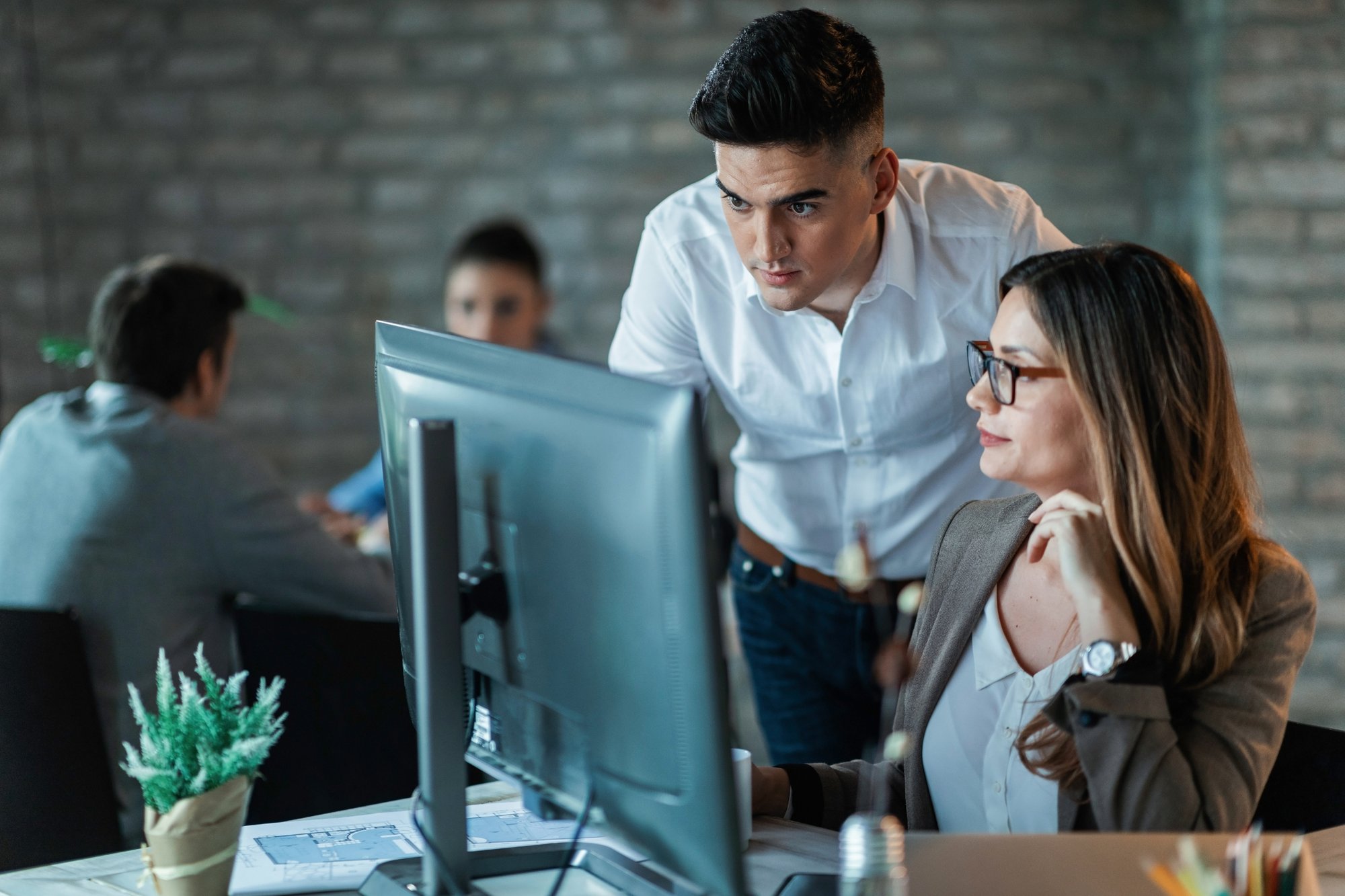 two-young-business-colleagues-using-desktop-pc-reading-email-while-working-together-office-focus-is-man two-young-business-colleagues-using-desktop-pc-reading-email-while-working-together-office-focus-is-man